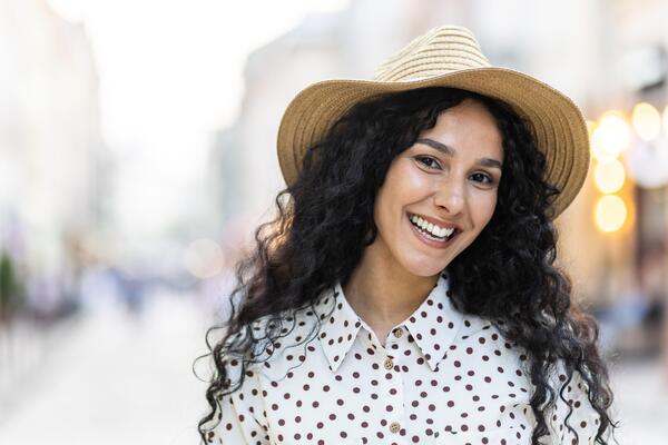 beautiful-young-latin-american-woman-portrait-woman-walking-in-evening-city-in-hat-with-curly-hair-in-warm-weather-smiling-and-looking-at-camera-close-up-photo beautiful-young-latin-american-woman-portrait-woman-walking-in-evening-city-in-hat-with-curly-hair-in-warm-weather-smiling-and-looking-at-camera-close-up-photo